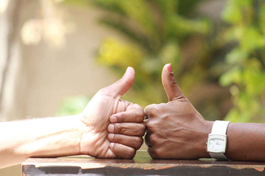 Two hands giving a thumbs-up fist bump, Client Satisfaction section